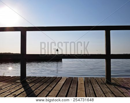Wharf Catwalk During Sunset Over Beautiful Lake With Cloudy Sky In The Background