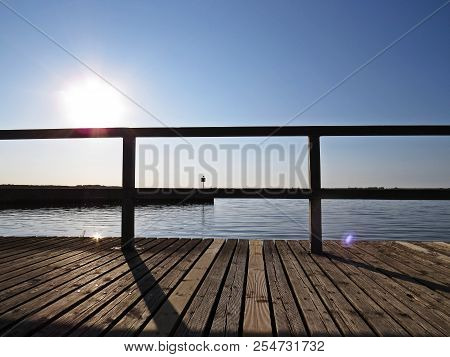 Wharf Catwalk During Sunset Over Beautiful Lake With Cloudy Sky In The Background