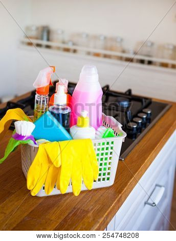 Basket With Cleaning Items On Blurry Background White Citchen. Cleaning Concept.