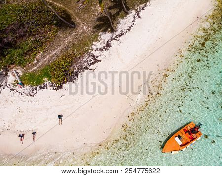 Aerial drone view of Petit Tabac tropical island, turquoise Caribbean sea of Tobago cays, and a family with kids in St Vincent and Grenadines
