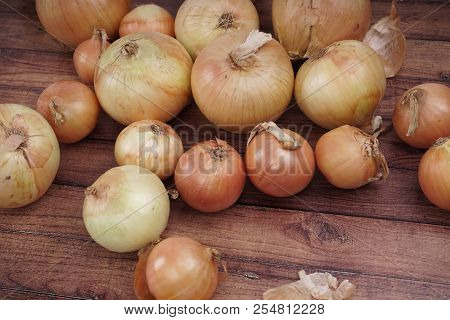Fresh Onion Bulbs On Wooden Background. Vegetables For A Healthy Diet. Bulb Onion Is Rich In Vitamin