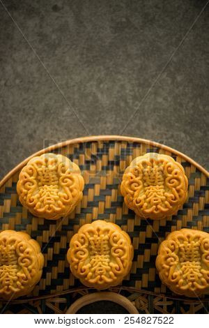 Traditional mooncakes is offered to friends or family during Mid-Autumn Festival. Flatlay on table, top down view dark light with copy space. The Chinese character represent 