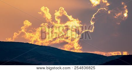 An Orange Fire-like Sunset Beyond The Distand Hills At Dusk