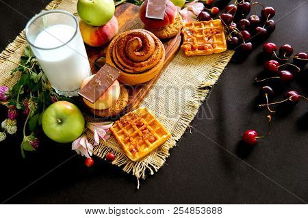 Homemade Cinnamon Buns In Glaze On A Dark Plate With Berries