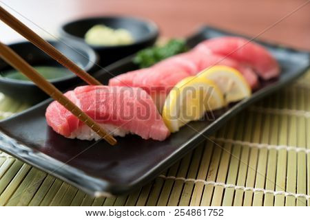 Otoro Tuna Sushi On Black Plate Along With Japanese Sauce And Green Leaf Decoration, Japanese Food, 