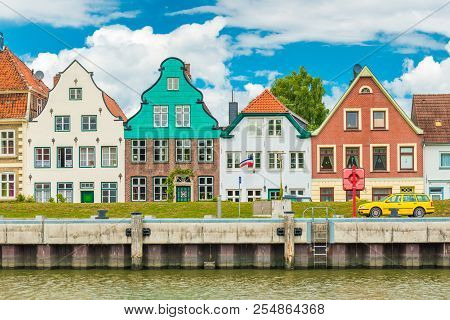 Small Beautiful European Town. Facades Of The Old Historical Colored Houses. Yellow Car Parked On Th