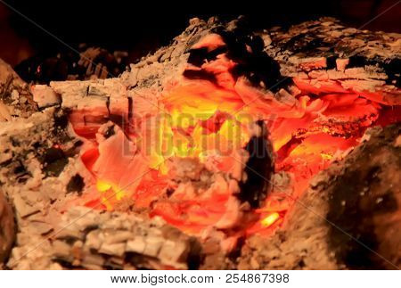 Burning Coals In The Fireplace On A Blurred Background, The Texture Of The Flame