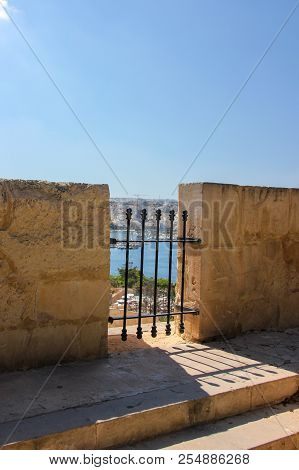 Fort Wall With Gap And Latice. Blue Sky, Shadows And Sun Light