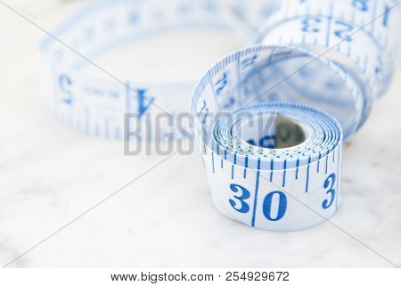 Measurring Tape Metter With Blue Figures Over Marbble Background. Control Weight, Loose Weight. Isoa