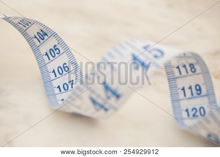 Measurring Tape Metter With Blue Figures Over Marbble Background. Control Weight, Loose Weight. Isoa
