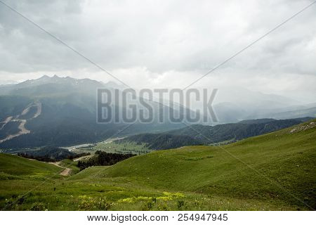 Green Slope Of A High Mountain During A Thunderstorm With Clouds
