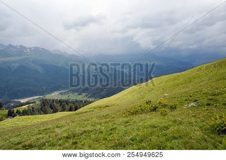 Green Slope Of A High Mountain During A Thunderstorm With Clouds