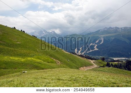 Green Slope Of A High Mountain During A Thunderstorm With Clouds