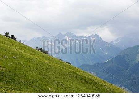 Green Slope Of A High Mountain During A Thunderstorm With Clouds