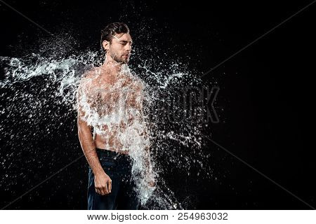 Side View Of Young Man With Eyes Closed Swilled With Water Splash Isolated On Black