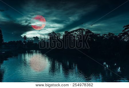 Beautiful Landscape Of Night Sky And Red Moon Or Blood Moon Behind Partial Cloudy Above Silhouettes 