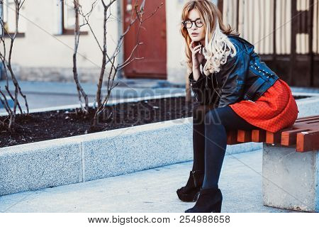  Girl Sitting on Bench. Street Fashion. Urban Lifestyle. Young Beautiful Woman Walking Outdoor.Image toned.