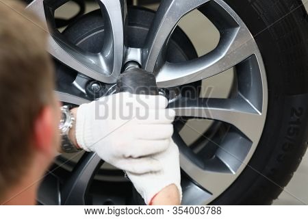Close-up View Of Mechanic Working With Wheel Tightening Or Loosening Bolts On Hub And Rim With Elect