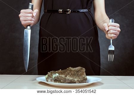 Woman With Beautiful Hands Holds A Fork And Knife. She Is Going To Cut Meat.