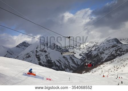 Chair-lift, Snowy Ski Track Prepared By Snowcat, Skiers And Snowboarders In Ski Resort. High Winter 