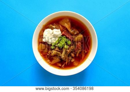 Borscht Soup In A White Bowl On Blue Background. Top View. Famous Traditional Ukrainian And Russian 
