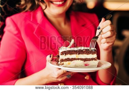 Close Up Image Of Woman Eating Cake Black Forest Decorated With White Chocolate And Raspeberries