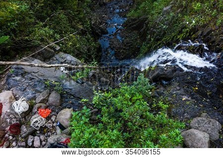 Ropes And A Variety Of Rappelling Gear On The Rocks Right Next To A 90 Foot Waterfall In The Tropica