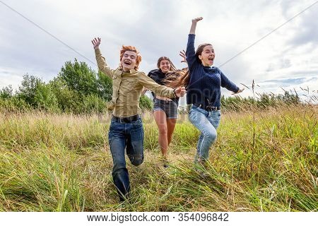 Summer Holidays Vacation Happy People Concept. Group Of Three Friends Boy And Two Girls Running And 