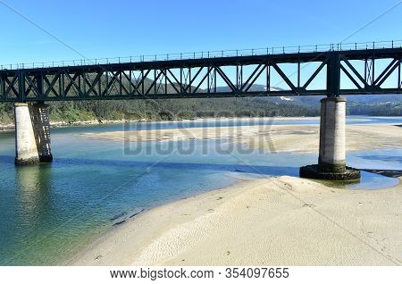 Beach With Forest And Train Bridge Over Sor Coastal River. O Barqueiro, A Coruña Province, Galicia, 