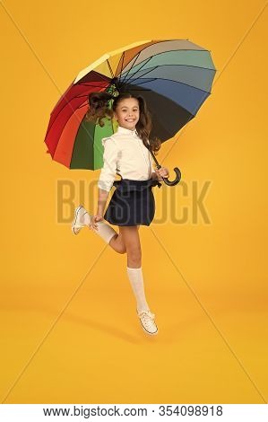 Back To School On September 1. Adorable Schoolgirl With Rainbow Umbrella On September 1 On Yellow Ba