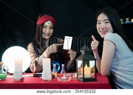 The Fortune-telling Woman Is Predicting The Fortune For A Beautiful Asian Woman By A Gypsy Card. It 