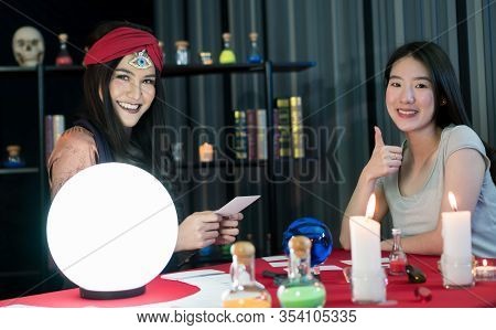 The Fortune-telling Woman Is Predicting The Fortune For A Beautiful Asian Woman By A Gypsy Card. It 