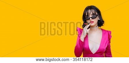 Stylish Caucasian Brunette Lady Is Holding A Lipstick While Looking Through Eyeglasses And Posing On