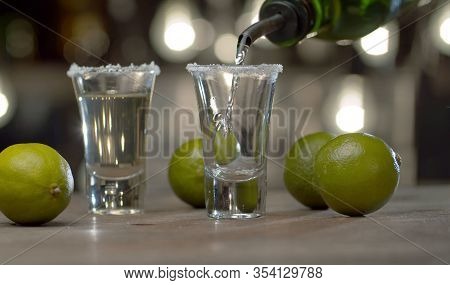 Bartender Pouring Tequila Into Glasses