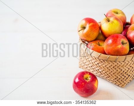Apples Harvest Concept. Braided Bamboo Basket With Red Apples On White Wooden Background With Copy S