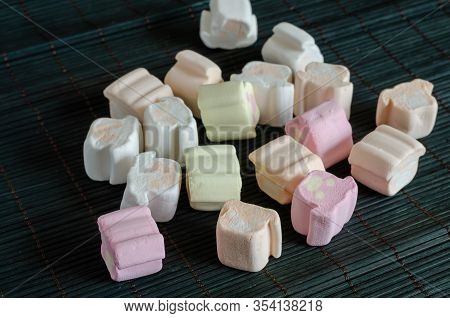 Multi-colored Marshmallows On A Dark Background. Group Of Marshmallows On A Bamboo Substrate. Close-