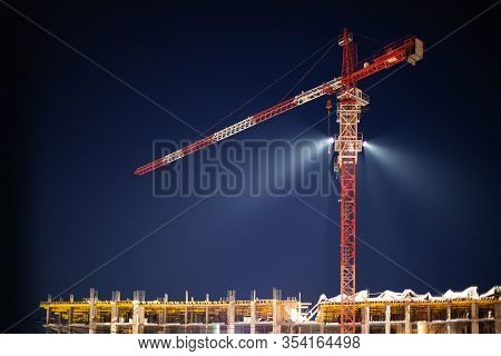 Construction Crane In Night Illumination, Construction Of A Multi-storey Modern Residential Building