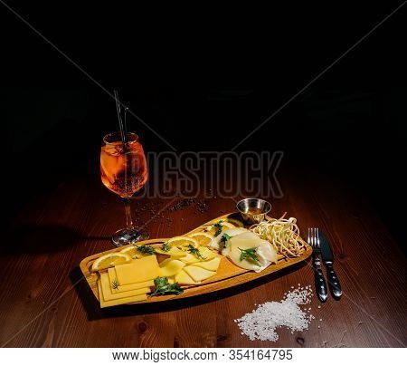 Assorted Different Types Of Cheese On A Wooden Board.