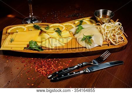 Assorted Different Types Of Cheese On A Wooden Board.