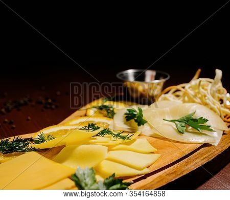 Assorted Different Types Of Cheese On A Wooden Board.