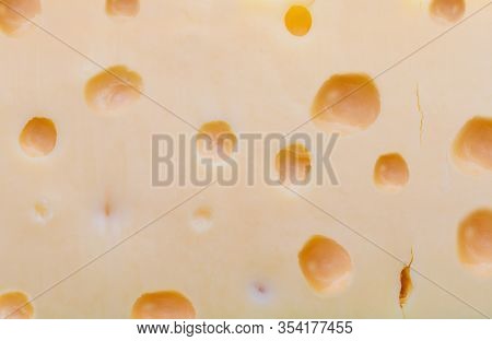 Close-up (macro) Emmental Swiss Cheese. Texture Of Holes And Alveoli.