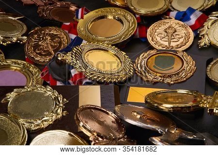 group of trophy and medals over blackboard background. top view. flat lay.Trophy is a specific achievement, serves as recognition / evidence of merit, awarded for sporting events