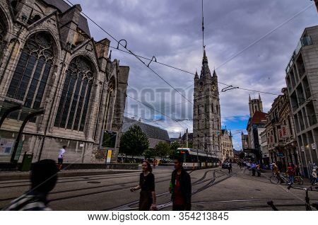 Ghent, Belgium, August 2019. The Bell Tower Called Beffroi Behind The Church Of St. Nicholas.