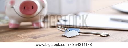 On Table Is Piggy Bank And Document With House Key. Transfer Property For Temporary Use, Not Ownersh