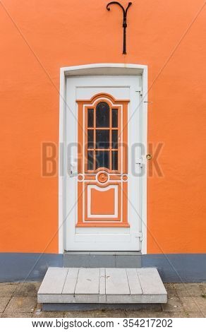 White Door In An Orange Wall Of An Old House In Husum, Germany