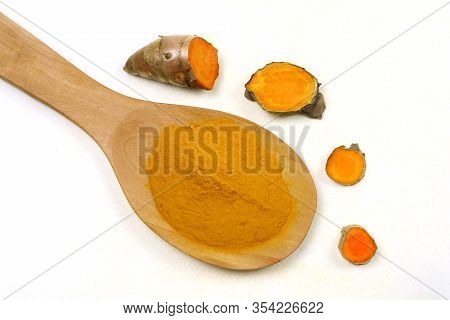 Turmeric Powder In A Wooden Spoon And Fresh Turmeric Roots Isolated On A White Background Is An Ingr