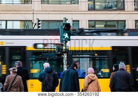Berlin, Germany - December, 2019: Street Life In Berlin. Pedestrians On Blurred Tram Background.