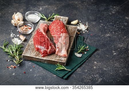 Raw Fresh Steak Sirloin Flap Served With Rosemary, Garlic And On Wooden Cutting Board. Black Angus B
