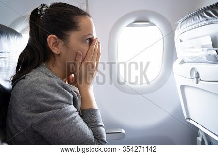 Young Woman Having Anxiety Attack In Airplane