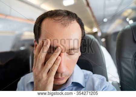 Young Man Suffering From Airsickness In Airplane